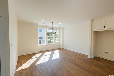 Unfurnished dining area with dark wood-type flooring, ornamental molding, a chandelier, and recessed lighting