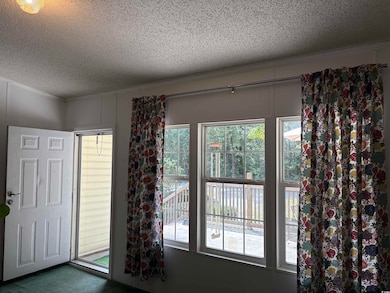 Entryway with a textured ceiling and carpet flooring