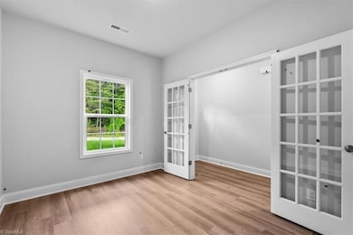 Office/flex space has French doors, adding nice architectural detail. View of entry.