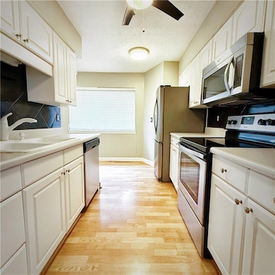 Kitchen with light wood finished floors, white cab