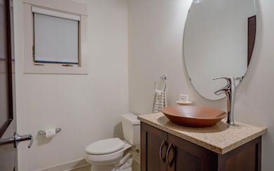 Modern powder room with sleek fixtures and a window that brings in natural light.