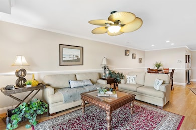 Living room with light wood-type flooring, recessed lighting, a ceiling fan, and ornamental molding