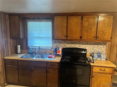 Kitchen featuring black / electric stove, sink, an