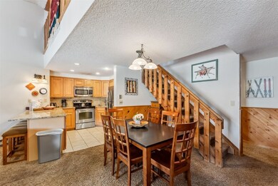 Dining room with light colored carpet, stairs, a c
