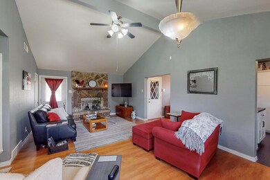 Living room with a fireplace, ceiling fan, and har