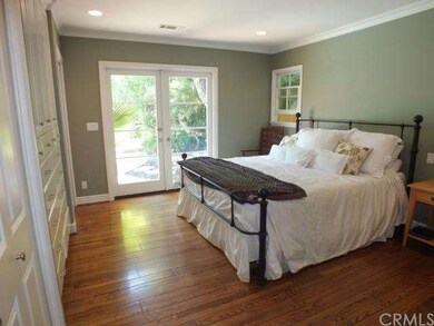Large, bright master bedroom with French doors to 