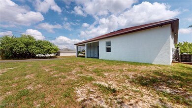 Back of house with stucco siding, a lawn, and cent