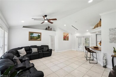 Living area featuring crown molding, french doors, plenty of natural light, and vaulted ceiling
