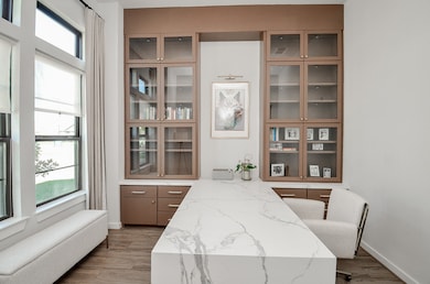 Elegant custom home office with built-in shelving and a sleek marble desk, perfect for productivity.
