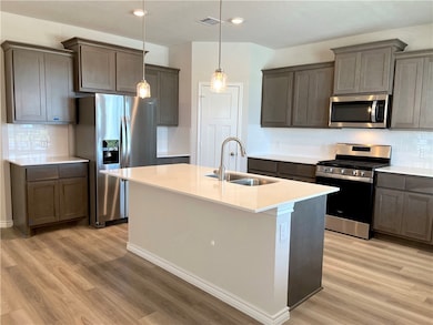 Kitchen with stainless steel appliances, a sink, l