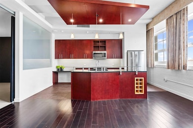 Kitchen featuring dark wood-style floors, recessed lighting, dark brown cabinets, tasteful backsplash, and appliances with stainless steel finishes