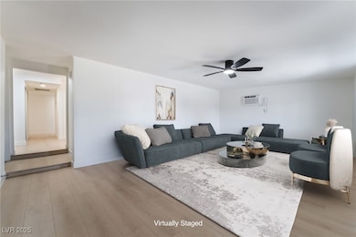 Living room featuring ceiling fan and light wood-t
