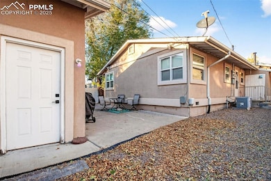 View of side of property with stucco siding and a patio