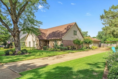 View of front of property featuring a front lawn, a garage, and stone siding