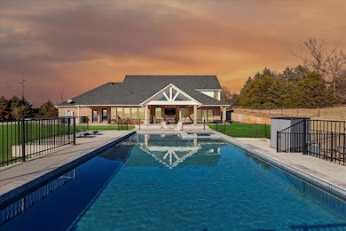 Pool at dusk featuring a yard, an outdoor structur