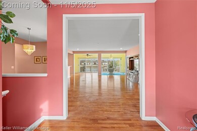 Hallway with light wood-style floors, a chandelier, and recessed lighting