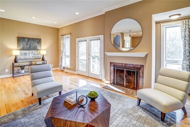 Living room with fireplace, hardwood floors, crown