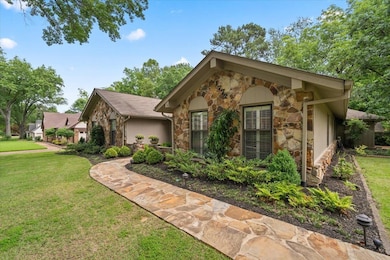 View of front of property featuring stone siding and a front lawn