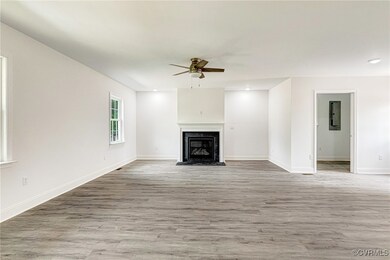 Unfurnished living room featuring baseboards, wood