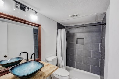 Full bath with a shower stall, toilet, visible ven