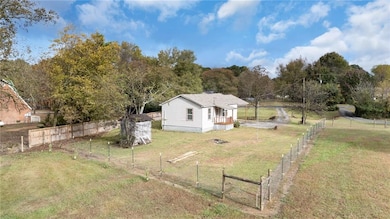Fenced yard with view of scattered trees