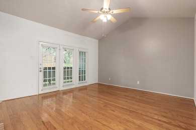 Empty room featuring light hardwood / wood-style floors, vaulted ceiling, and ceiling fan