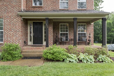 Front porch with wood beams and sitting area.