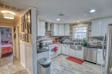 Kitchen with wall chimney exhaust hood, sink, orna
