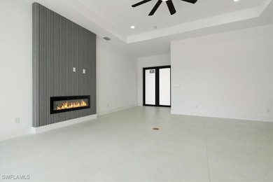 Unfurnished living room featuring a raised ceiling