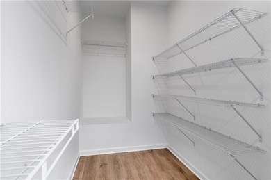 Walk in closet featuring wood finished floors