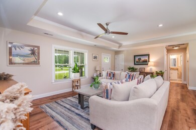 Living room featuring ornamental molding, a raised