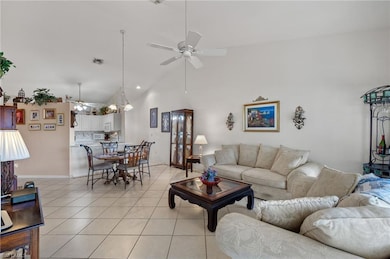 Living room featuring ceiling fan, high vaulted ce