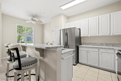 Kitchen with white cabinetry, a center island, cei