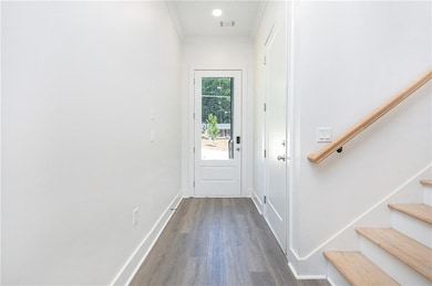 Doorway to outside with stairway, wood finished floors, and crown molding