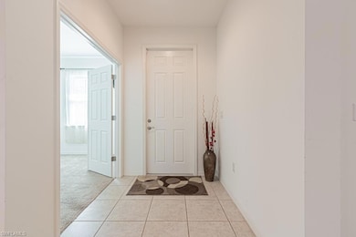 Hallway featuring light tile patterned floors, bas