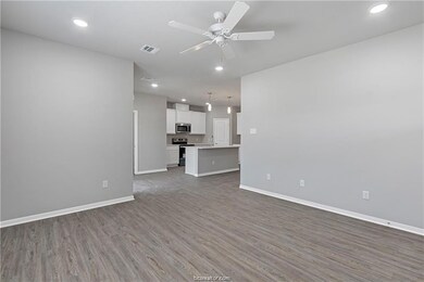 Unfurnished living room featuring ceiling fan and
