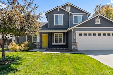 Craftsman inspired home featuring stone siding, driveway, and a shingled roof