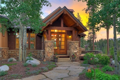 Exterior entry at dusk with stone siding and frenc