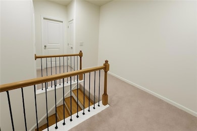 Hall featuring an upstairs landing, carpet, and baseboards