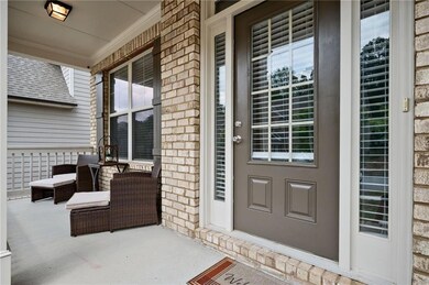 Entrance to property with a porch and brick siding