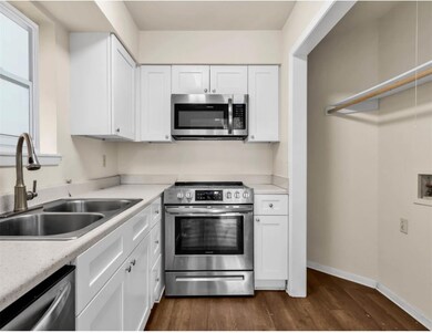 Kitchen featuring dark wood-style floors, a sink,
