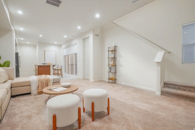 Living area featuring stairway, light carpet, and recessed lighting