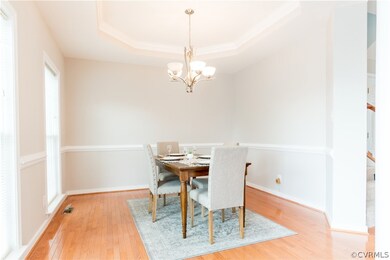 Dining Room with Tray Ceiling, Chair Rail, and Har