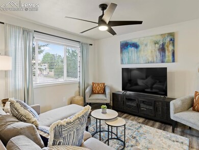 Living room with wood finished floors and a ceiling fan