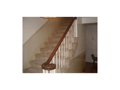 Entry features elegant stairway.