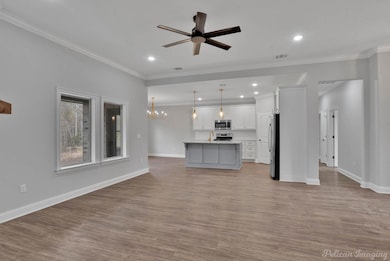 Unfurnished living room featuring ceiling fan with