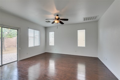 Empty room featuring dark wood-style floors and a ceiling fan