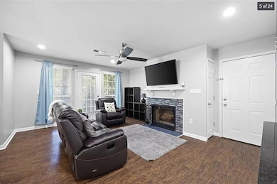 Living area featuring a fireplace, ceiling fan, ba
