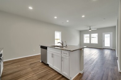 The kitchen opens into the dining room and living room all looking onto the backyard.
