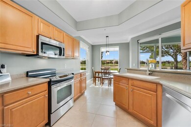 Kitchen with appliances with stainless steel finishes, a sink, light countertops, light tile patterned floors, and ornamental molding